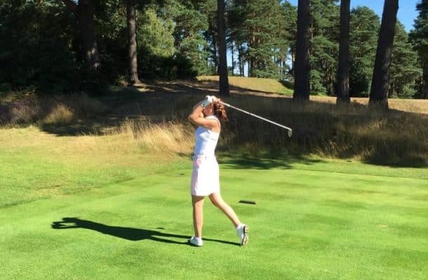 female playing golf in golf club