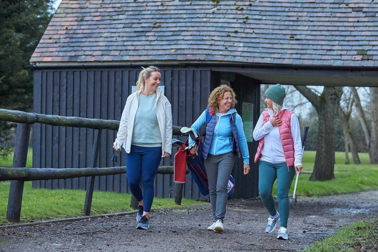 3 women walking through a golf course 